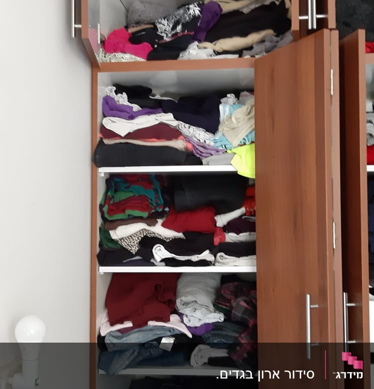 ארון בגדים פתוח עם בגדים מקופלים על מדפים